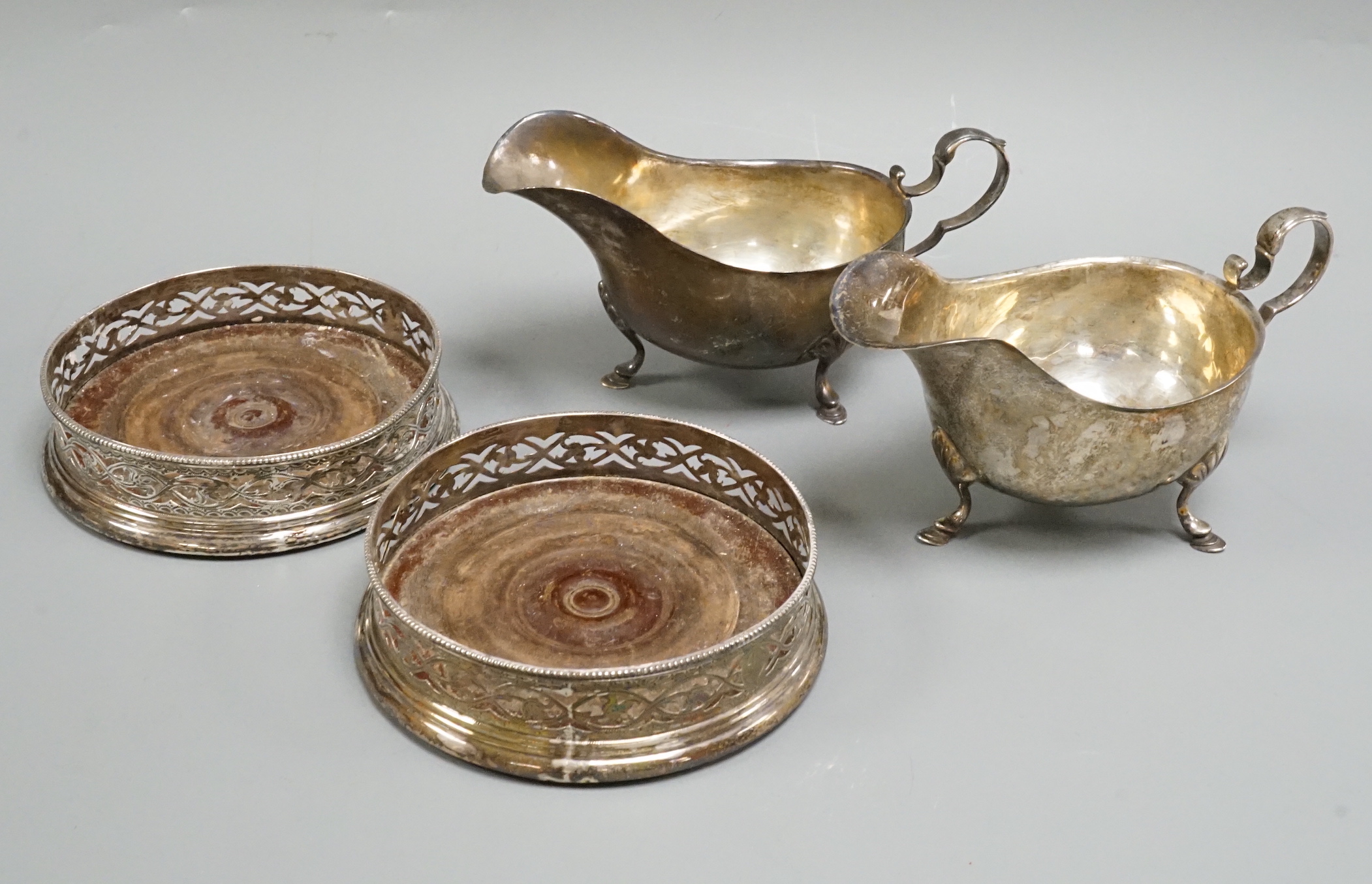 A pair of George III pierced silver coasters, William Plummer, London, 1779, 12cm and a pair of sterling sauceboats.